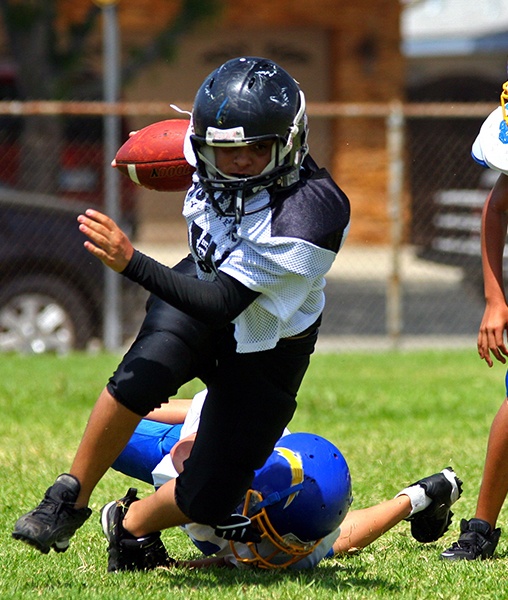 Teen playing football with athletic mouthguard