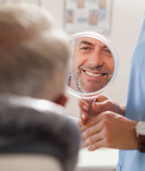 Man looking at smile after full mouth reconstruction