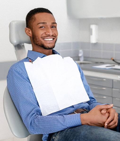 Male dental patient smiling during routine checkup appointment