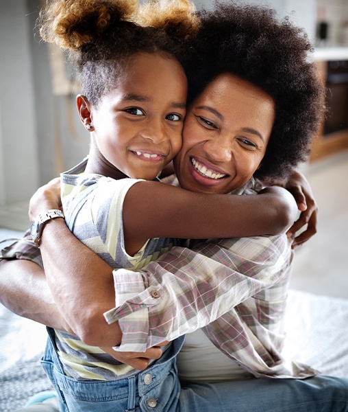 Mother giving daughter a hug after dental checkups