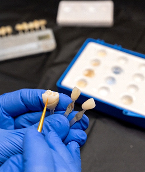 Technician in dental laboratory working on porcelain crown