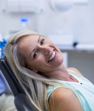 person sitting in a dental chair and smiling 