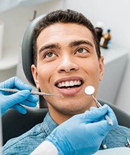 Man smiling while looking at dentist during checkup