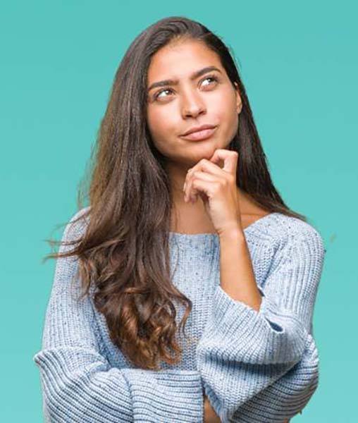 Woman thinking while touching her chin and looking upwards