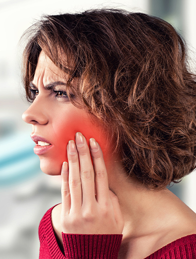 Woman in pain holding cheek before tooth extraction