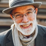 Older man smiling after replacing missing teeth