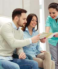 Young couple learning about options for paying for dental implants