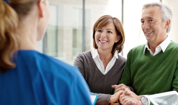 Man and woman discussing dental insurance coverage with team member