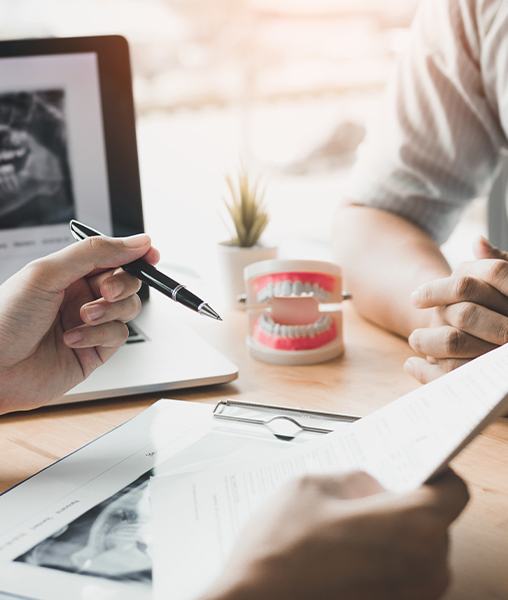 Dentist and patient examining dental insurance forms