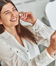 Woman smiling while looking at reflection in mirror
