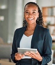 Woman smiling while holding tablet in office