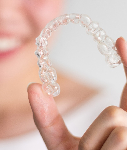 Woman holding aligner for Invisalign in York, PA