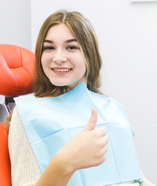 Patient giving thumbs up for scaling and root planing treatment