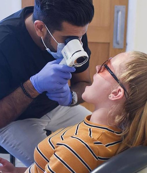 Dentist performing oral cancer screening