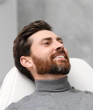 Handsome dental patient smiling in mirror