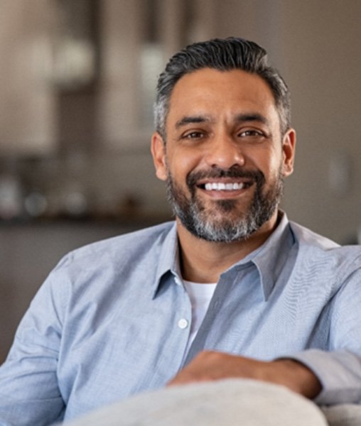 Man in blue shirt smiling at home