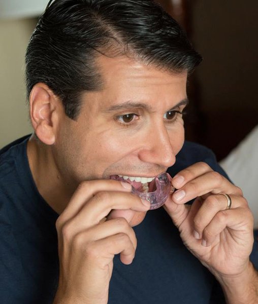 Man placing sleep apnea oral appliance