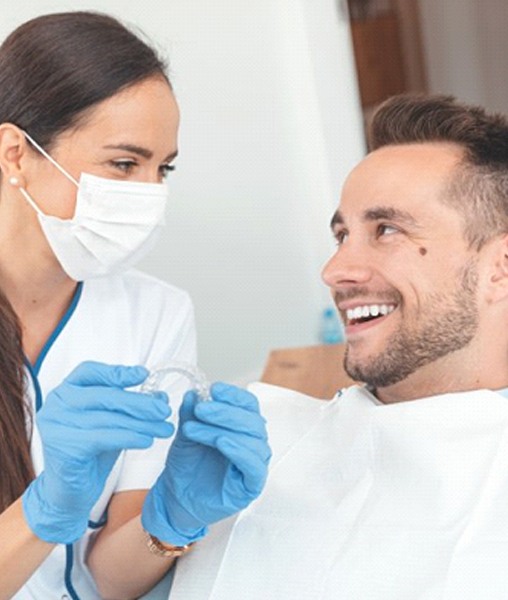 Patient and dentist discussing cost of SureSmile in York