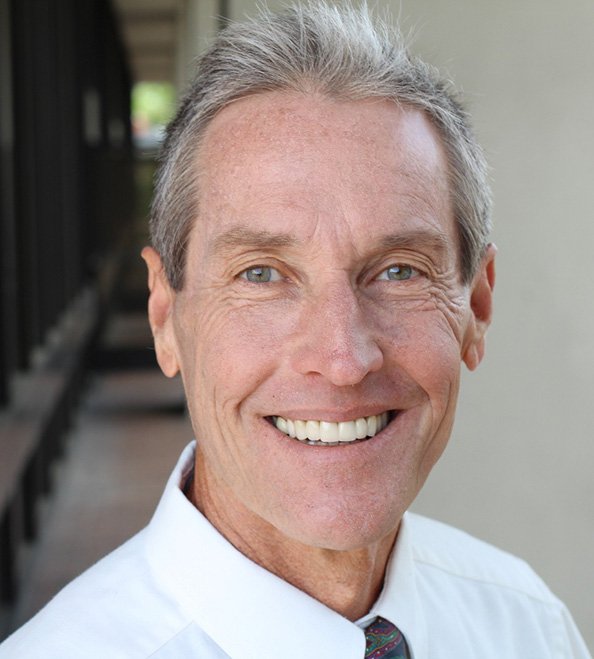 Man smiling outside of an office
