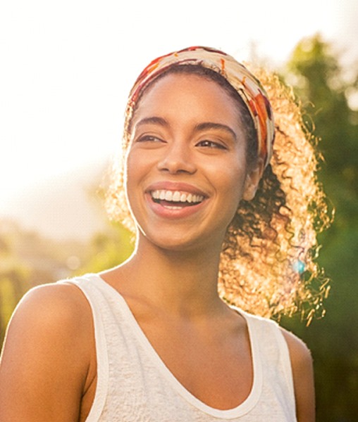 Smiling young woman enjoying benefits of tooth-colored fillings