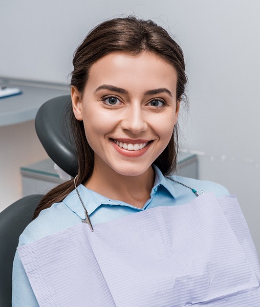 Female patient sitting in dental chair and smiling