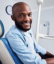 Bearded man sitting in dental chair and smiling