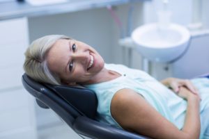 Happy dental implant candidate reclining in dentist's chair