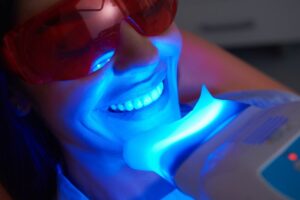 Young man getting teeth whitening treatment. 